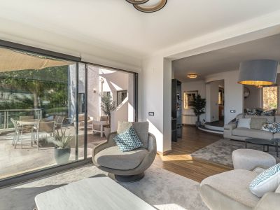 Moderne woonkamer met royale glazen deuren die naadloos op het terras aansluiten, een adembenemend panoramisch uitzicht op de Middellandse Zee en veel daglicht bieden.
