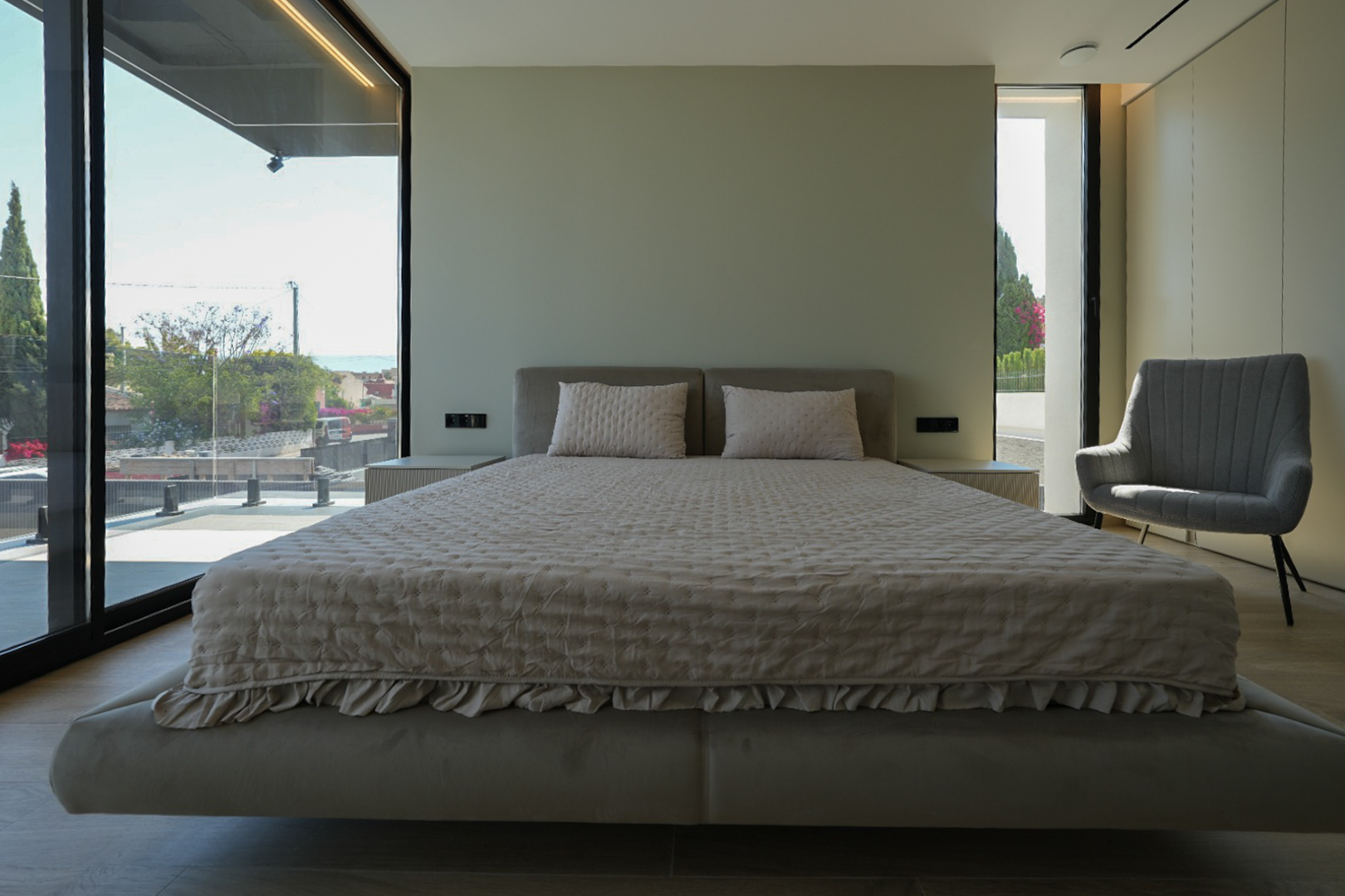 Hoofdslaapkamer met zwevend bed, gestoffeerd hoofdeinde, grote ramen met zeezicht en fauteuil. Geïntegreerde nachtkastjes.