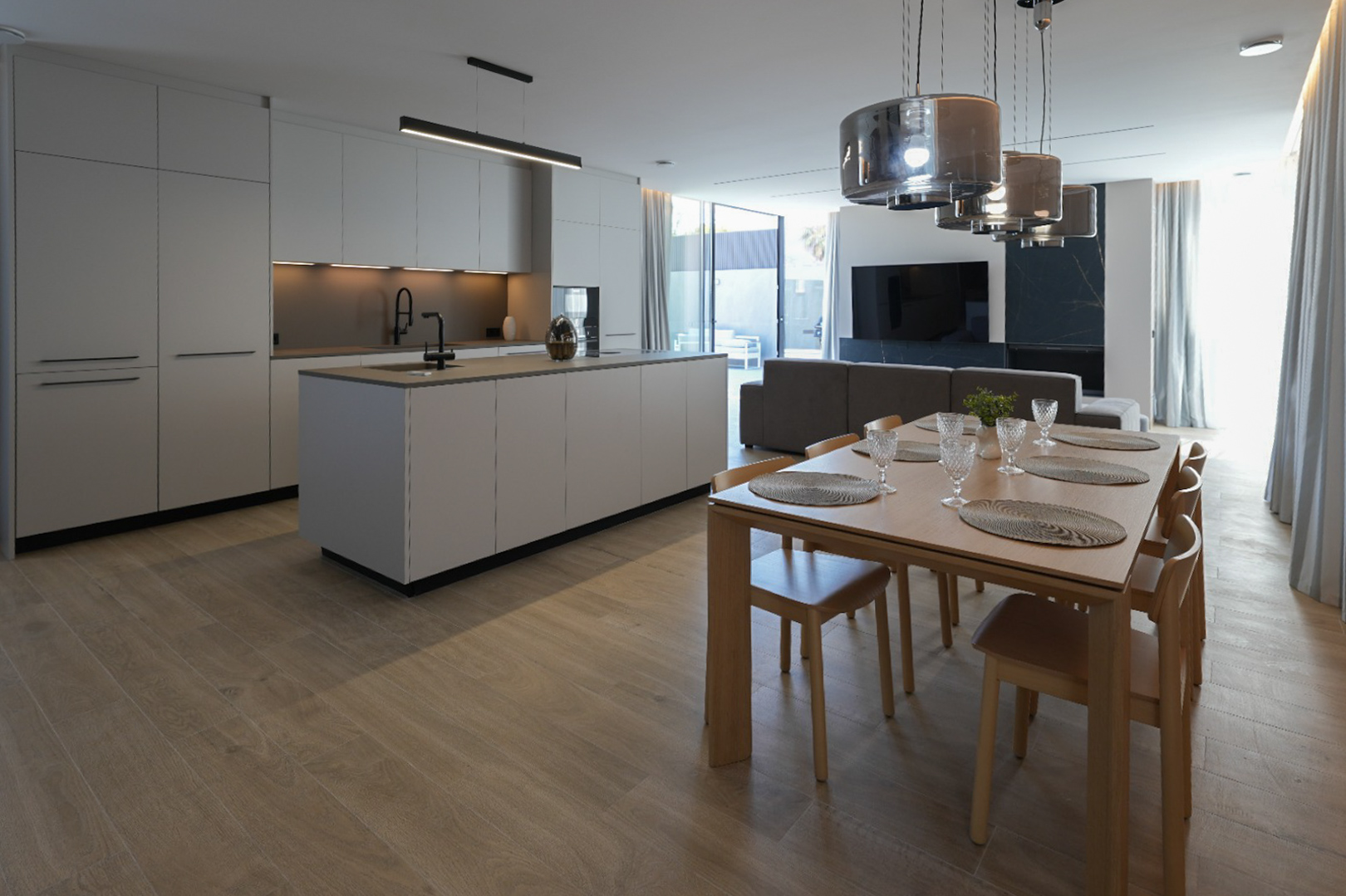 Minimalistische designkeuken met kookeiland en zwarte kraan, open naar een elegante houten eethoek met zes stoelen en moderne hanglampen.