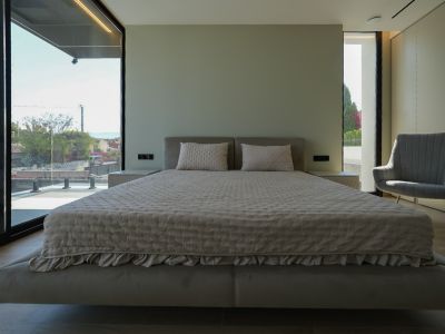 Hoofdslaapkamer met zwevend bed, gestoffeerd hoofdeinde, grote ramen met zeezicht en fauteuil. Geïntegreerde nachtkastjes.
