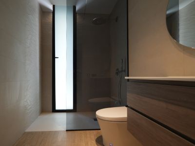 Moderne badkamer met houten badmeubel, ronde spiegel en inloopdouche. Voorzien van getextureerde wandtegels en een matglasraam.