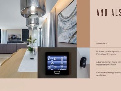 Open woon-eetkamer met houten tafel, hanglampen en geïntegreerd domoticascherm, aangevuld met een zichtbare beveiligingssensor.