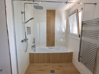 Badkamer met douche en bad