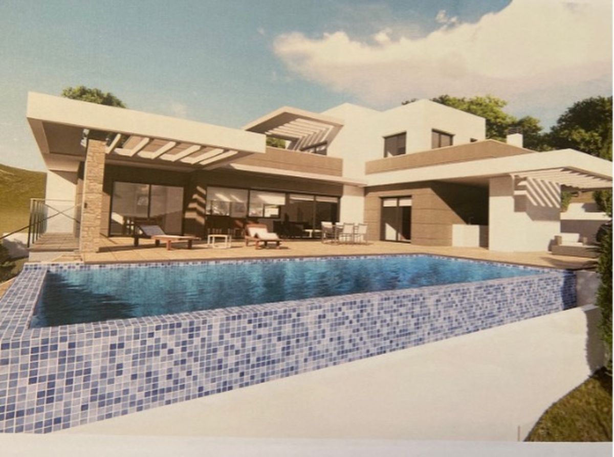 Moderne villa met overloopzwembad in blauw mozaïek, ruim zonneterras en eigentijdse architectuur met stenen accenten en grote raampartijen.