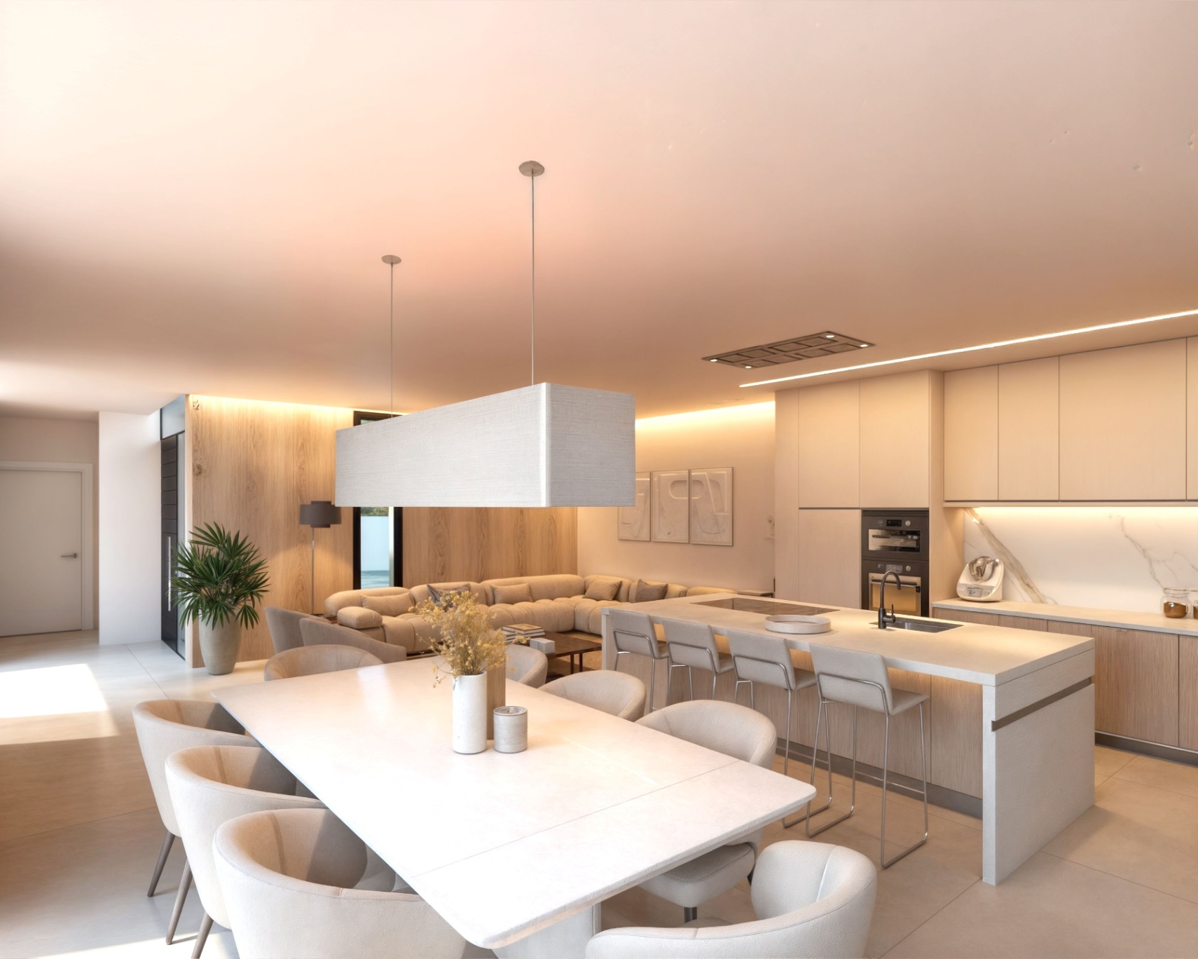 Open woonruimte met een kookeiland met watervalrand, inbouwapparatuur en een eethoek met een grote stoffen hanglamp en houten wandpanelen.