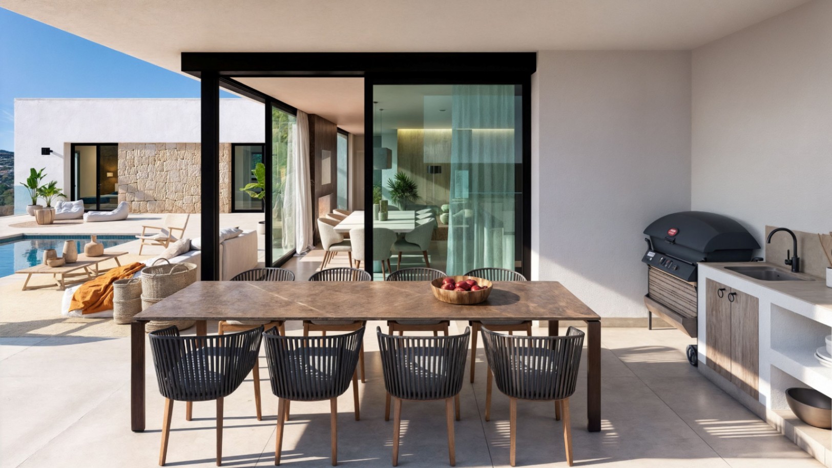 Overdekt terras met een grote houten eettafel, moderne touwstoelen en een buitenkeuken met barbecue en spoelbak, grenzend aan het zwembad.