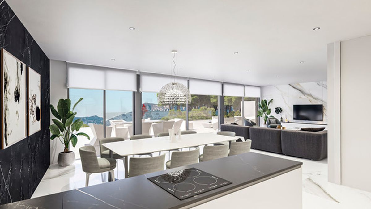 Open woonkamer met witte eettafel, donker kookeiland en zithoek. Voorzien van marmeren accentmuren en kamerhoge ramen die uitkijken op het omliggende landschap.