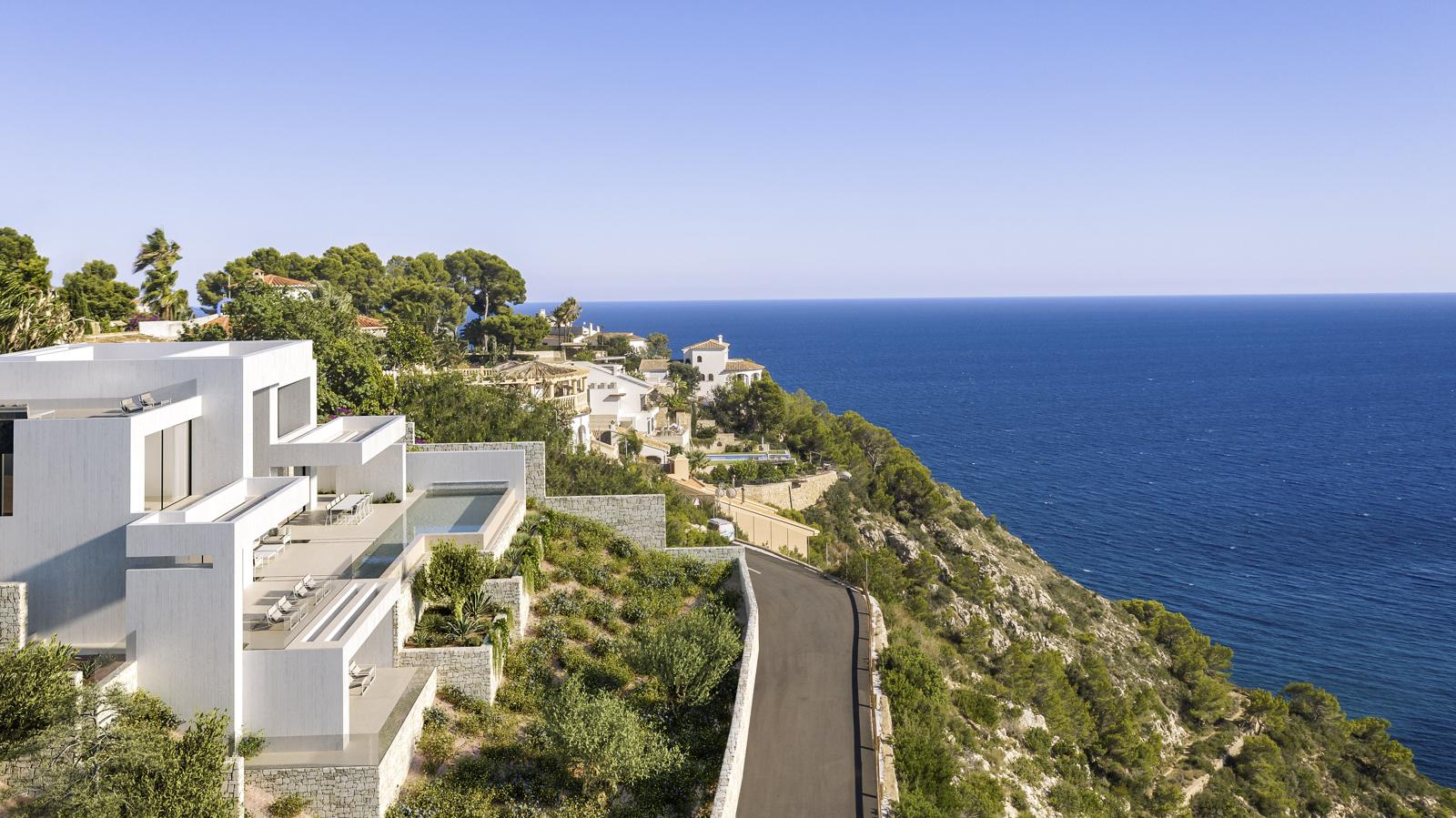Exterieur van de moderne witte villa met terrasvormige verdiepingen, overloopzwembad en panoramisch uitzicht op de Middellandse Zee in La Granadella.