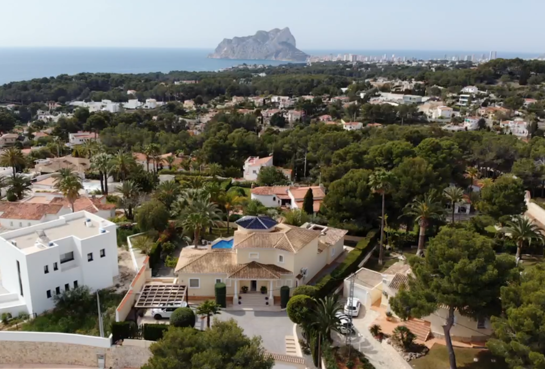 Luchtfoto van de villa met traditionele architectuur, blauwe koepel en een ruim perceel met panoramisch uitzicht op de Middellandse Zee en de Peñón de Ifach.