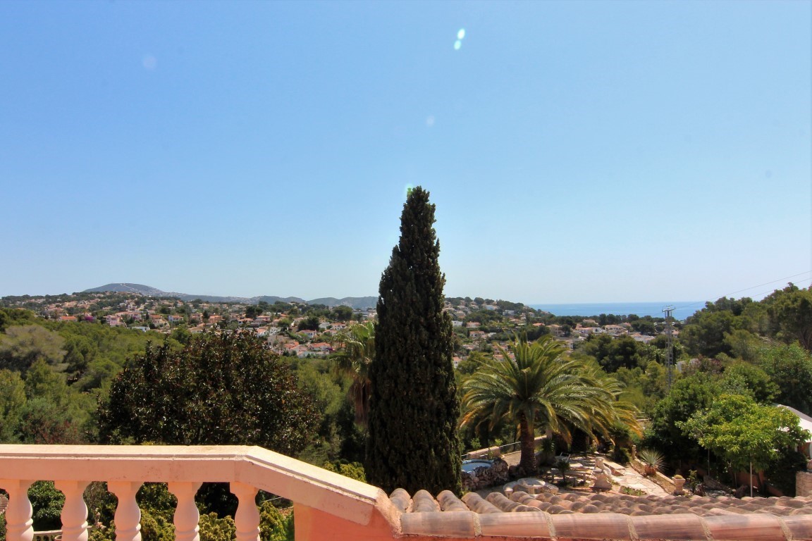 Panoramisch uitzicht vanaf het bovenste terras met klassieke balustrade, uitkijkend over de mediterrane begroeiing, woonwijk en de zee.