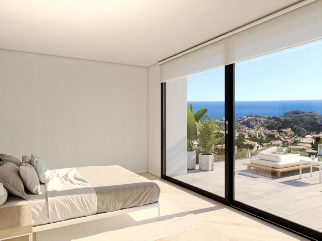 Moderne slaapkamer met kamerhoge schuifpui die toegang biedt tot een terras met panoramisch uitzicht op de Middellandse Zee.