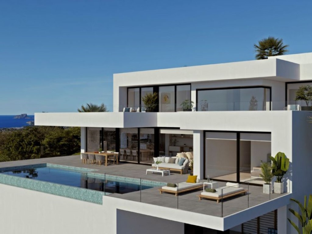 Moderne witte villa met een overloopzwembad van turquoise mozaïek en een ruim terras. Grote raampartijen zorgen voor een vloeiende overgang tussen binnen en buiten met zeezicht.