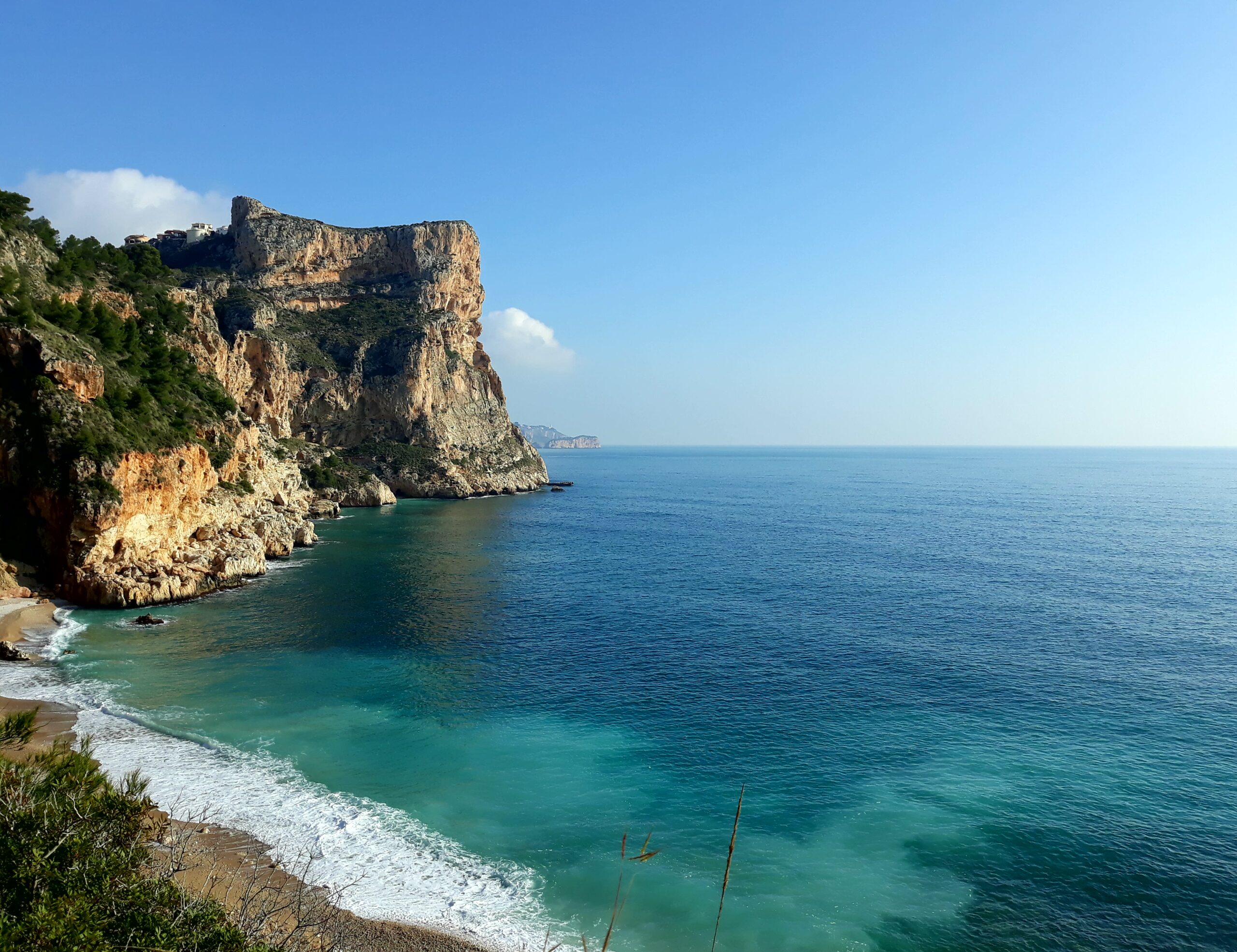 Panoramisch uitzicht op de ruige kalkstenen kliffen en het turquoise water van de Middellandse Zee rondom Cumbre del Sol.