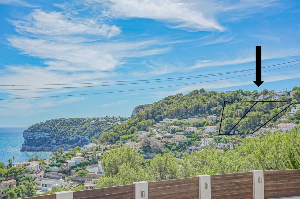 Verhoogd panoramisch uitzicht met de gemarkeerde kavels op de beboste heuvel, uitkijkend over de Middellandse Zee en de rotsachtige kustlijn van Jávea.