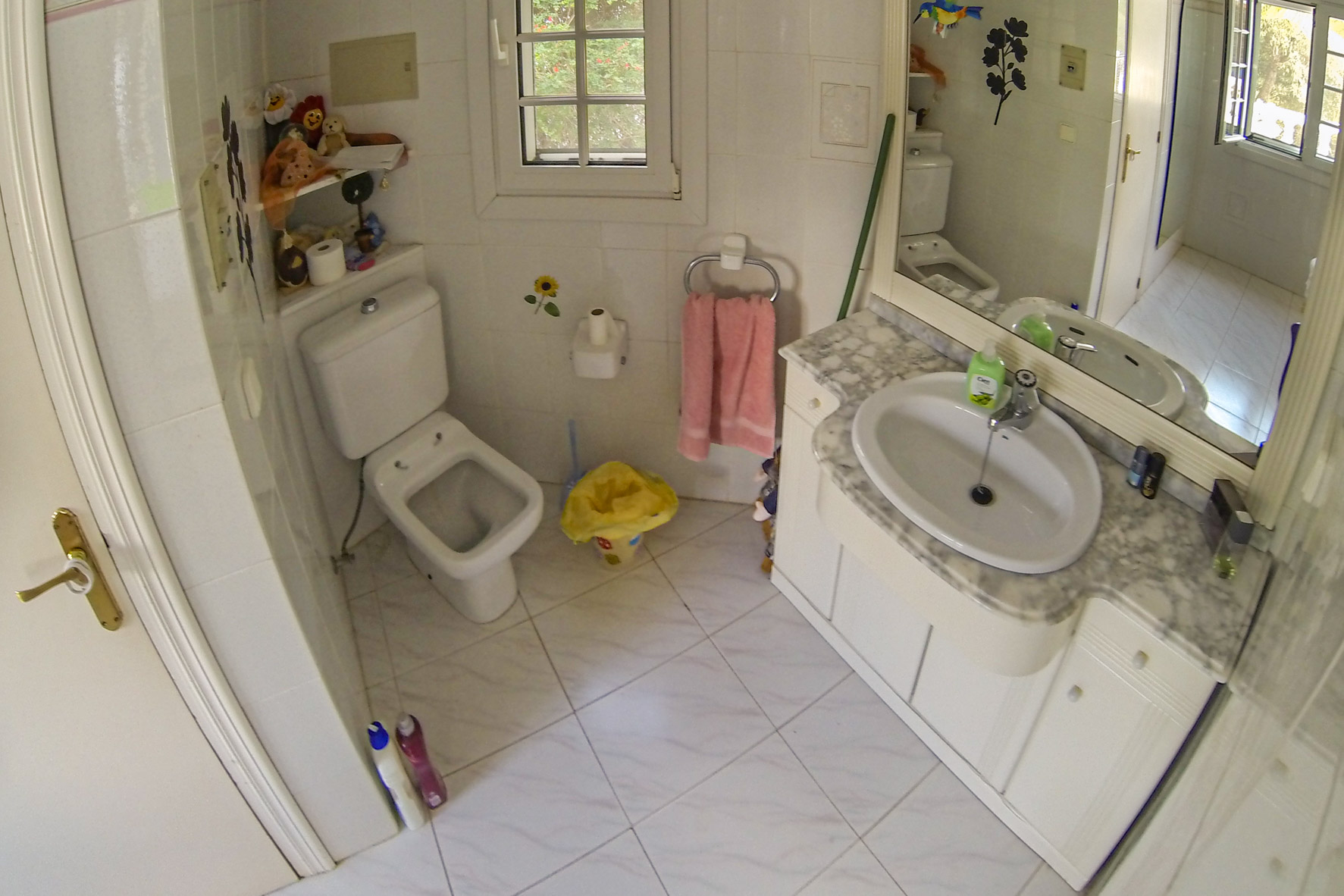 Badkamer met marmeren wastafel, toilet en witte tegels.