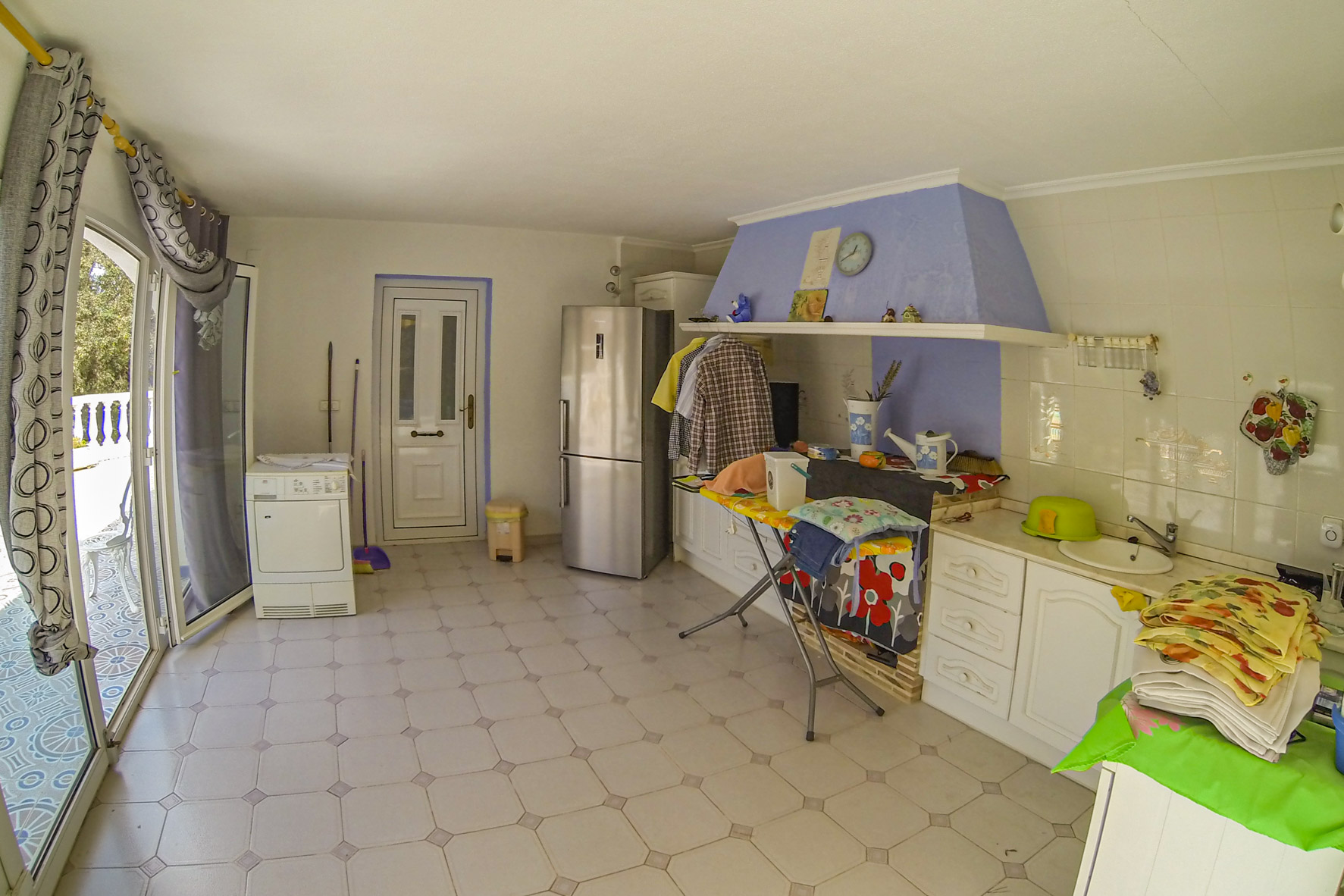 Functionele keuken met moderne apparatuur en witte werkbladen.