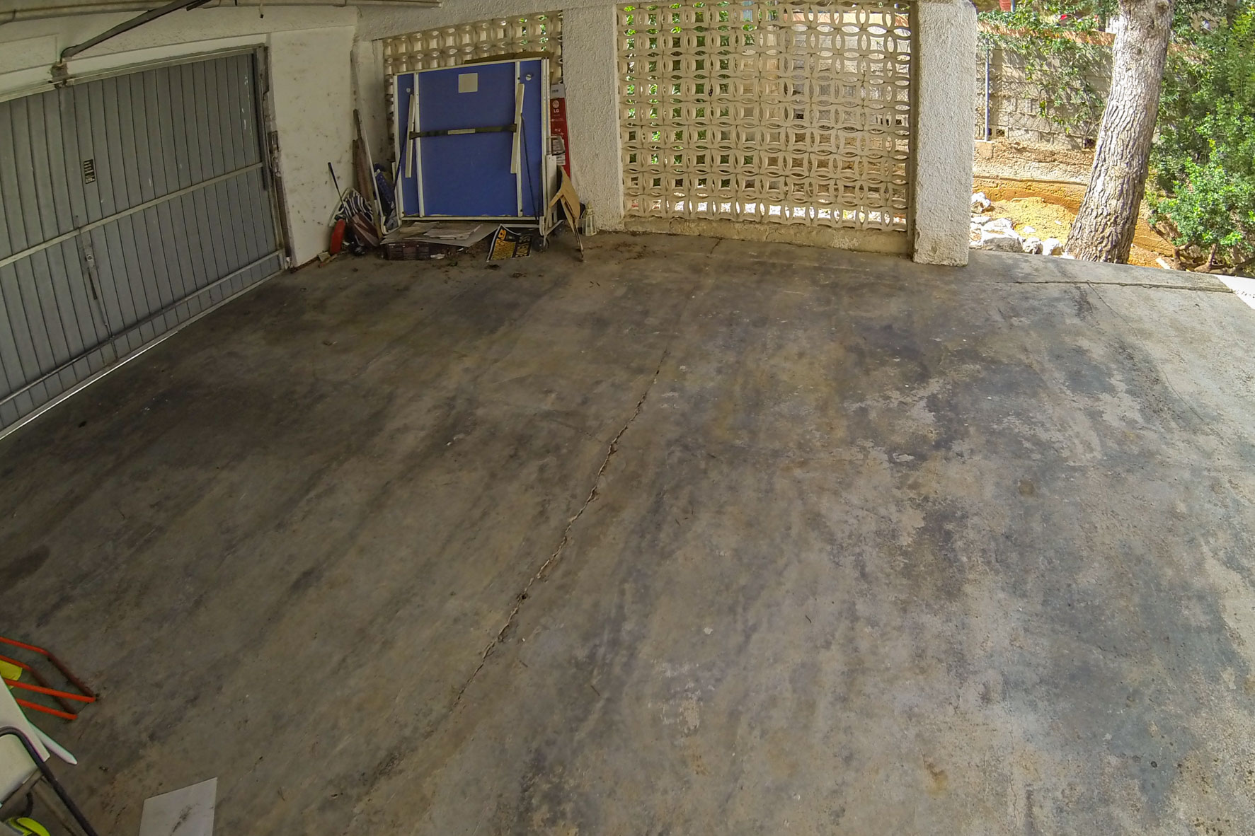 Garage met metalen deur en decoratieve blokmuur.