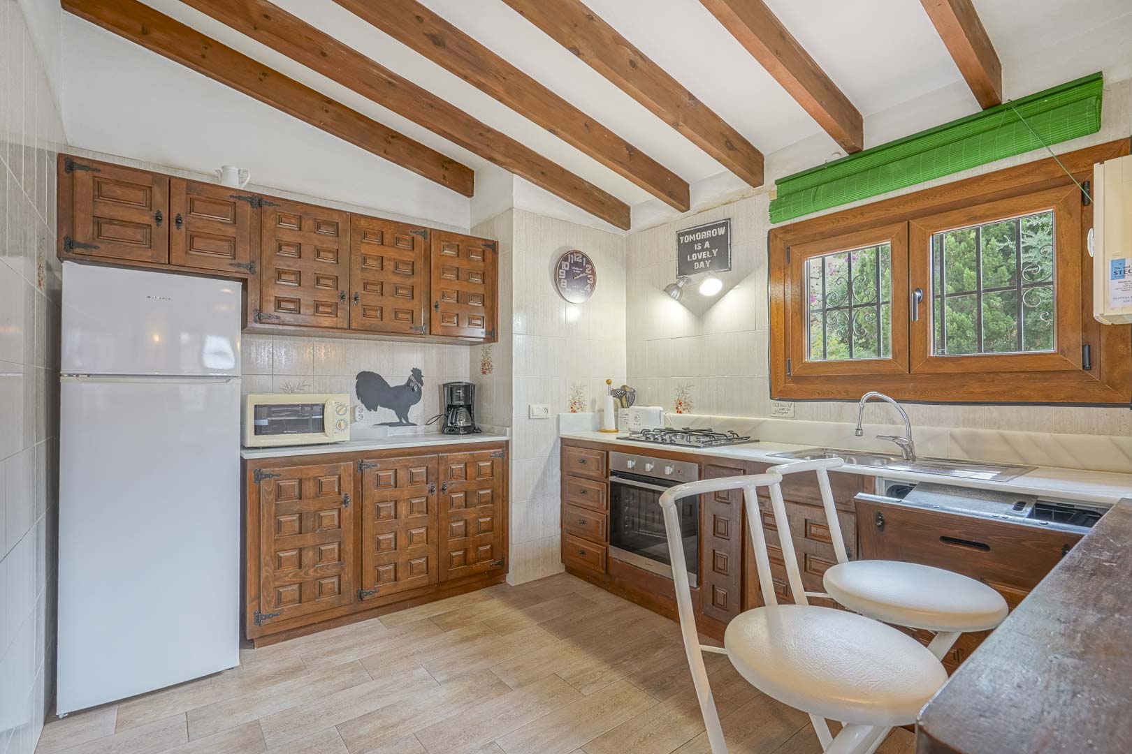 Rustieke keuken met houten balkenplafond, gesneden houten kasten en moderne apparatuur.