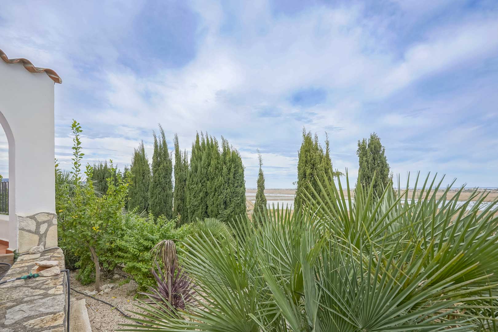 Tuinzicht met cipressen en palmbomen, vanaf het terras van de villa in Monte Pego.