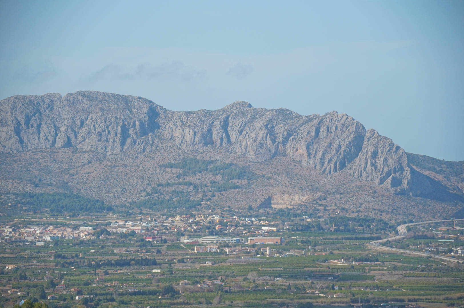 Panoramisch uitzicht op de ruige bergen en de vallei, met de strategische ligging nabij de snelweg en het mediterrane landschap van Pedreguer.