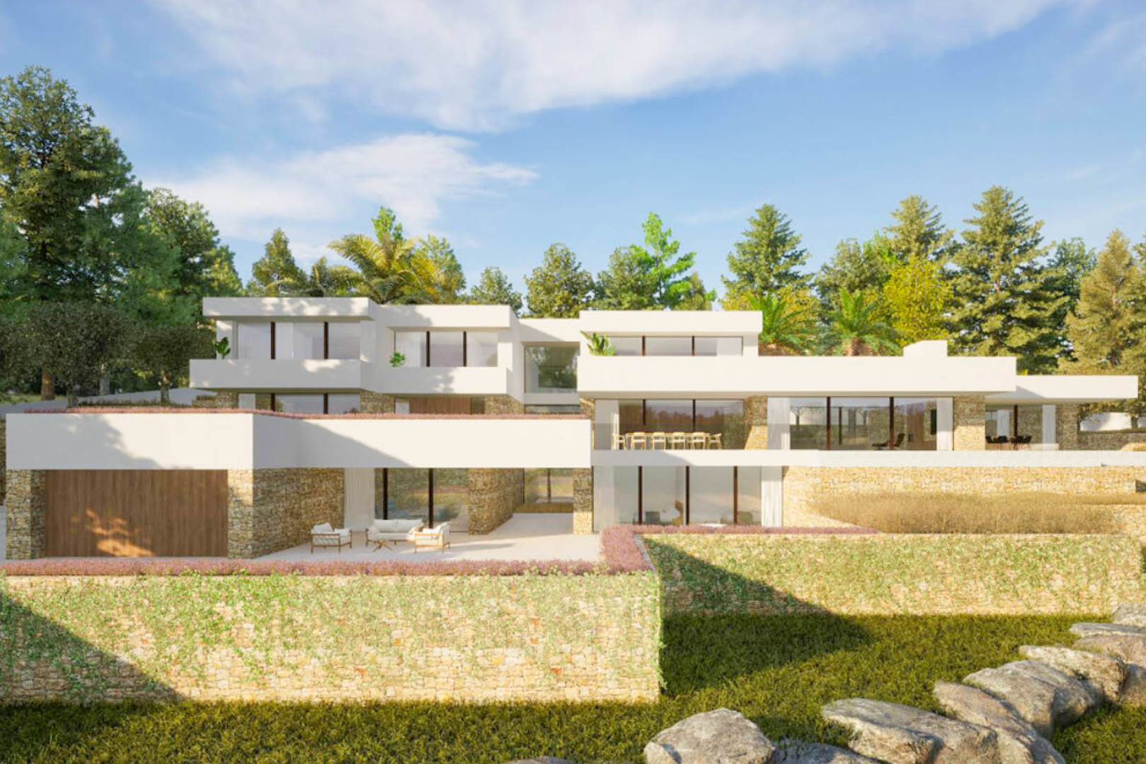 Externe gevel van de villa in Ibiza-stijl, met natuurstenen muren, grote glazen puien en terrassen die naadloos opgaan in het mediterrane landschap.
