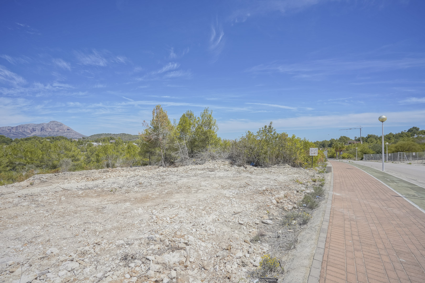 Bouwperceel van 1.000 m2 in Jávea met vrij uitzicht op de Montgó, gelegen aan een verhard voetpad binnen een volledig ontwikkelde woonwijk.