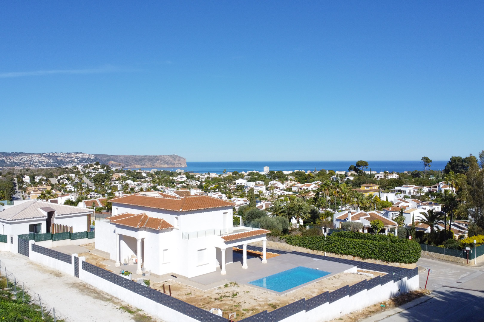Luchtfoto van de villa in Pinosol met een pannendak, rechthoekig zwembad en panoramisch uitzicht op de Middellandse Zee en de kust van Jávea.