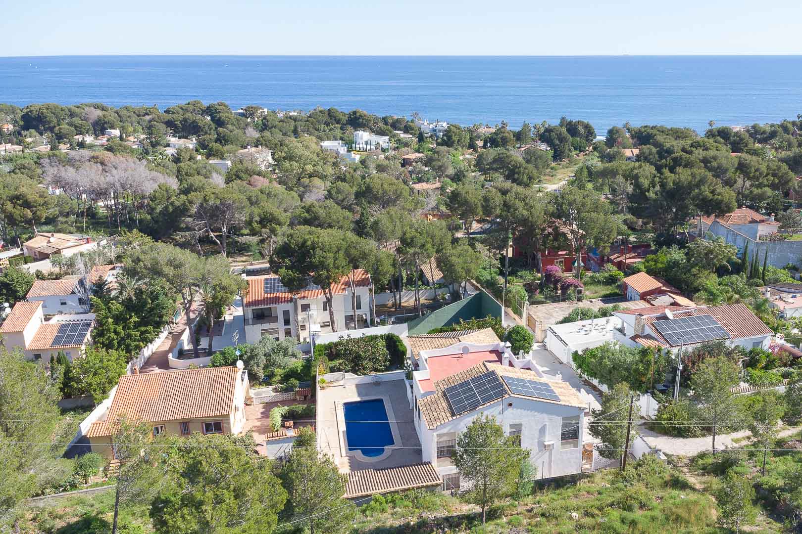 Luchtfoto van de villa met privézwembad en zonnepanelen, gelegen in de bosrijke omgeving van Las Rotas met uitzicht op de Middellandse Zee.