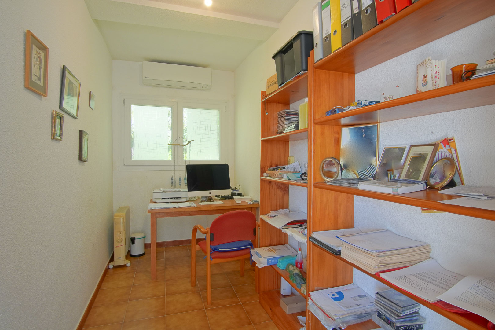 Functionele werkkamer met houten bureau, ruime opbergkasten, tegelvloer en airconditioning, perfect ingericht als rustige thuiswerkplek.