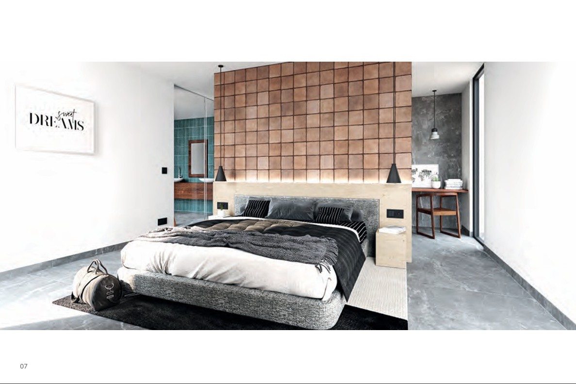 Hoofdslaapkamer met een accentmuur van terracotta tegels, houten hoofdbord met geïntegreerde verlichting en een en-suite badkamer achter glas.