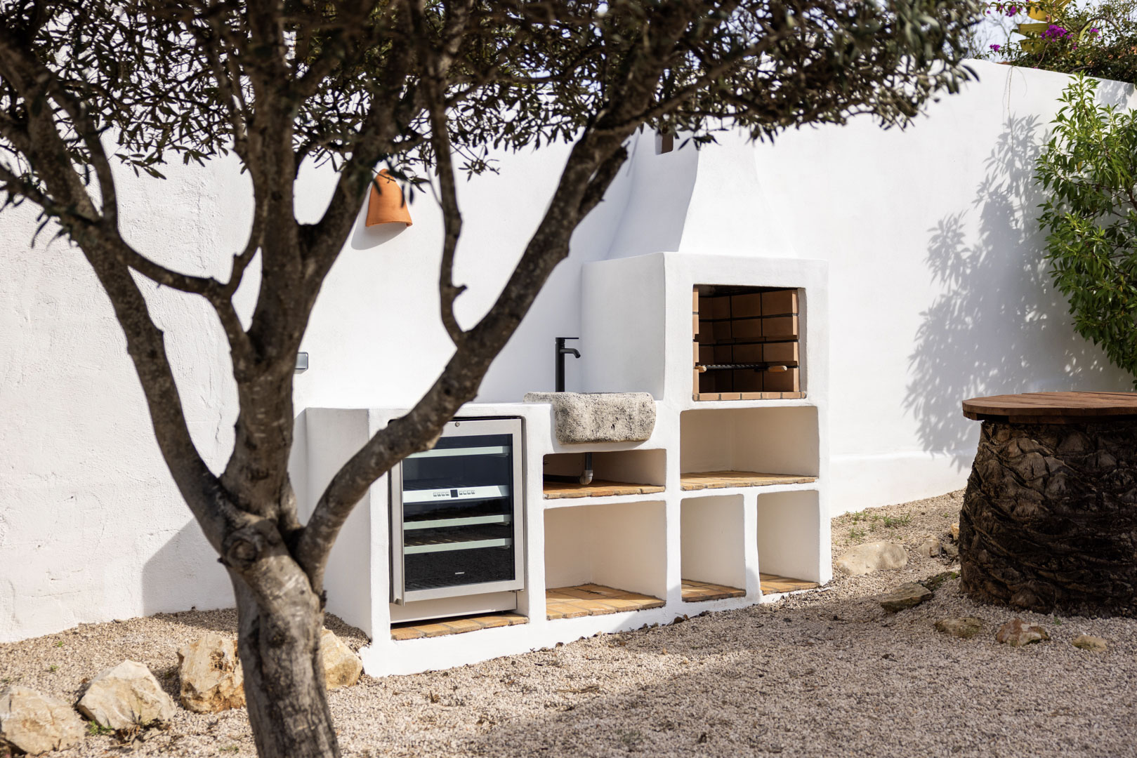 Detail van de buitenkeuken met ingebouwde BBQ, stenen gootsteen en wijnkoelkast in Tosalet, Jávea.