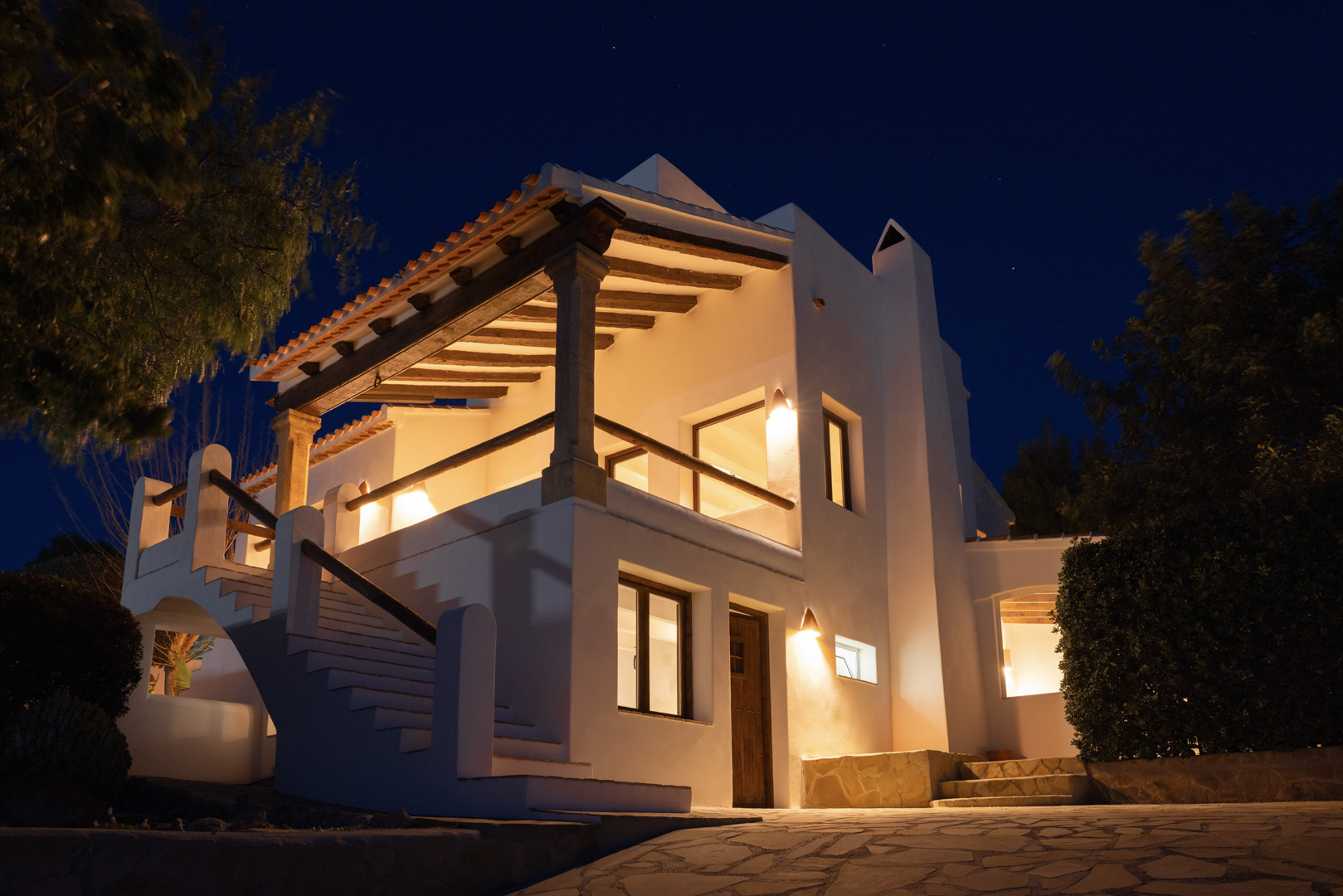 Nachtzicht op villa in Tosalet, Jávea. Mediterrane architectuur met overdekt terras, warme verlichting en stenen details.
