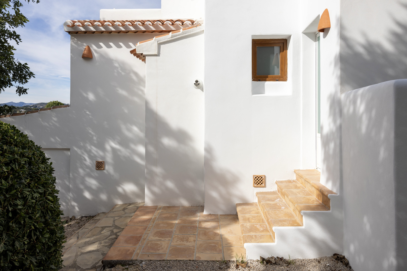 Villa exterieur in Jávea met witte muren, terracotta dakpannen en toegangstrap.