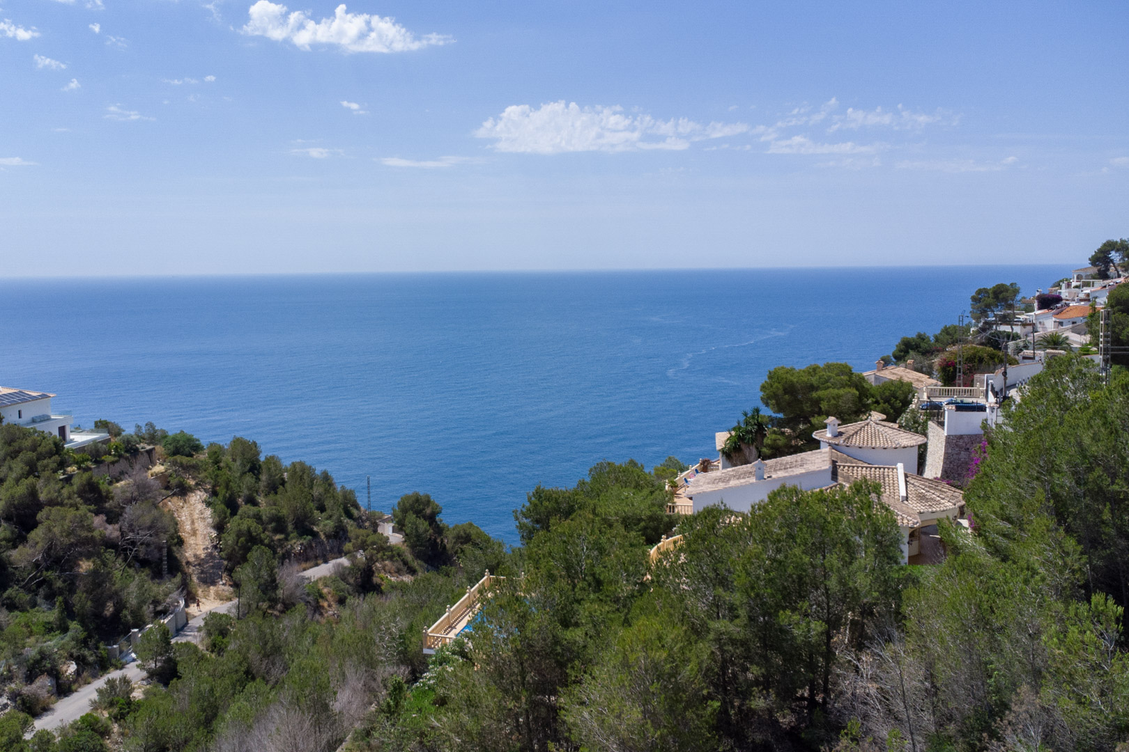 Panoramisch uitzicht op de Middellandse Zee vanaf de hoogten van Costa Nova, met dennenbossen en omliggende villa's aan de kust van Jávea.