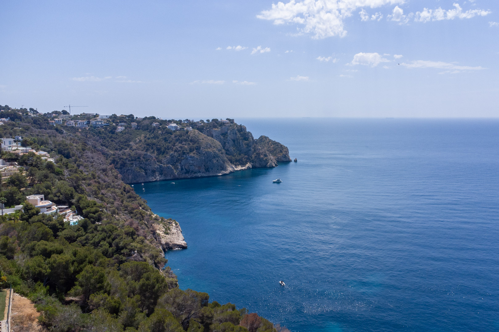 Verhoogd uitzicht op de kustlijn van Granadella in Jávea, met rotsachtige kliffen, mediterrane dennenbossen en een weids uitzicht over de diepblauwe zee.