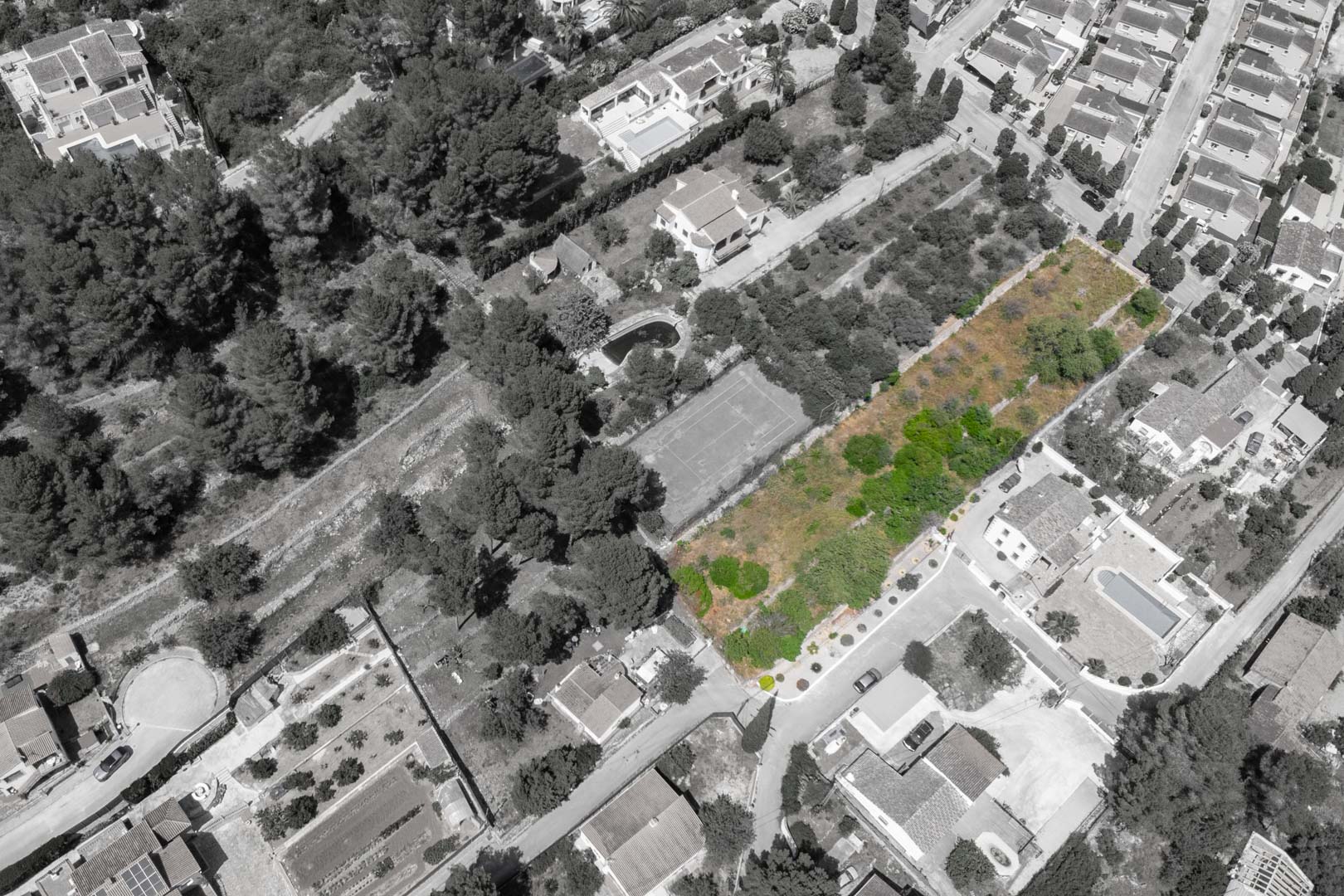 Luchtfoto van het gemarkeerde perceel in Alcalalí, gelegen in een volgroeide woonwijk nabij bestaande villa's en omgeven door natuurlijke begroeiing.