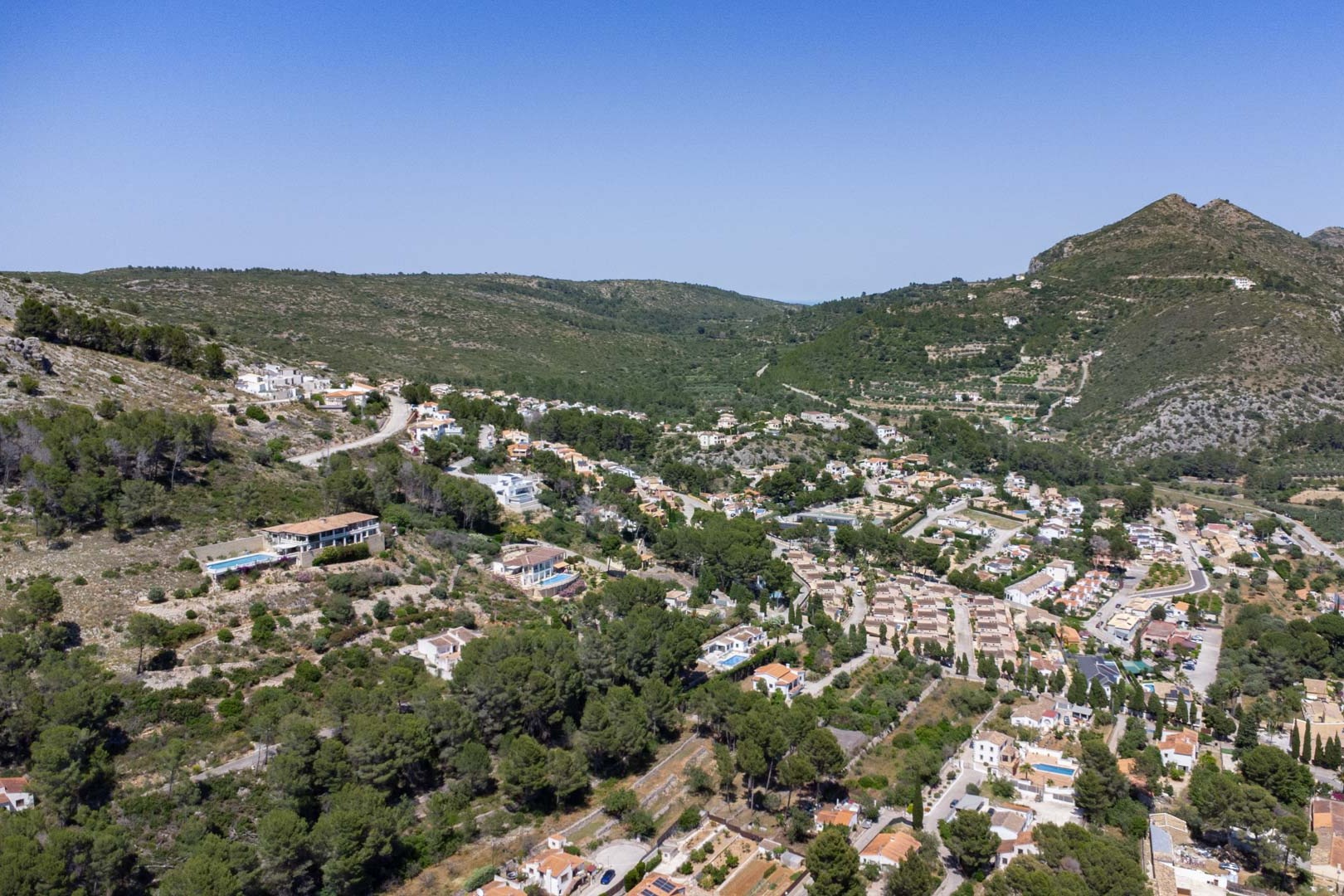 Panoramisch luchtfoto van de Jalón-vallei en Alcalalí, met de verhoogde ligging van het project omgeven door mediterrane natuur en bergen.