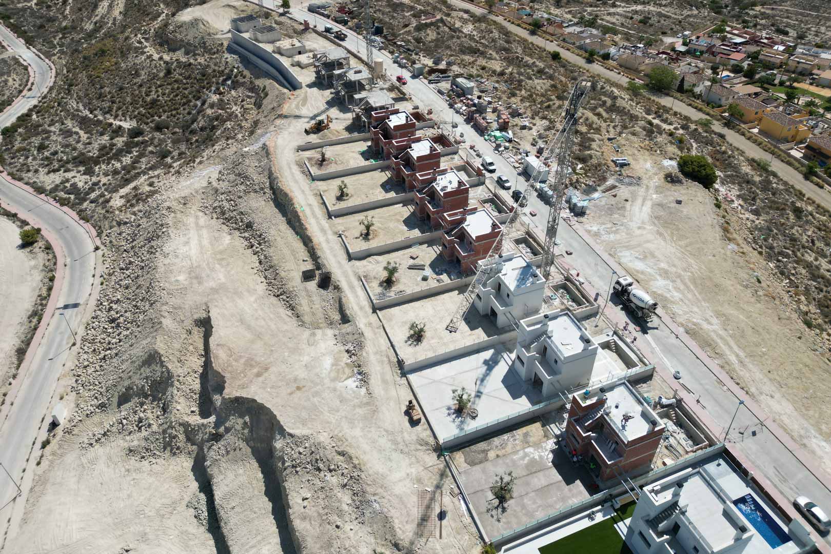 Luchtfoto van het villaproject in aanbouw, met weergave van de verhoogde ligging op de heuvel en de indeling van de moderne architecturale woningen.