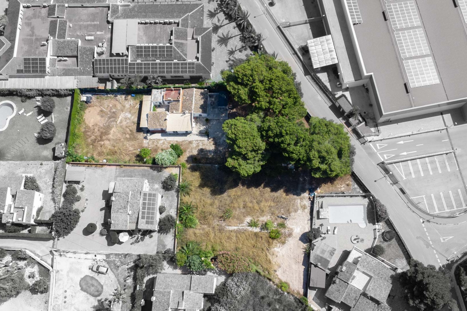 Bovenaanzicht van het perceel van 2.600 m² met de bestaande woning, volgroeide pijnbomen en de gunstige ligging nabij commerciële voorzieningen in Jávea.