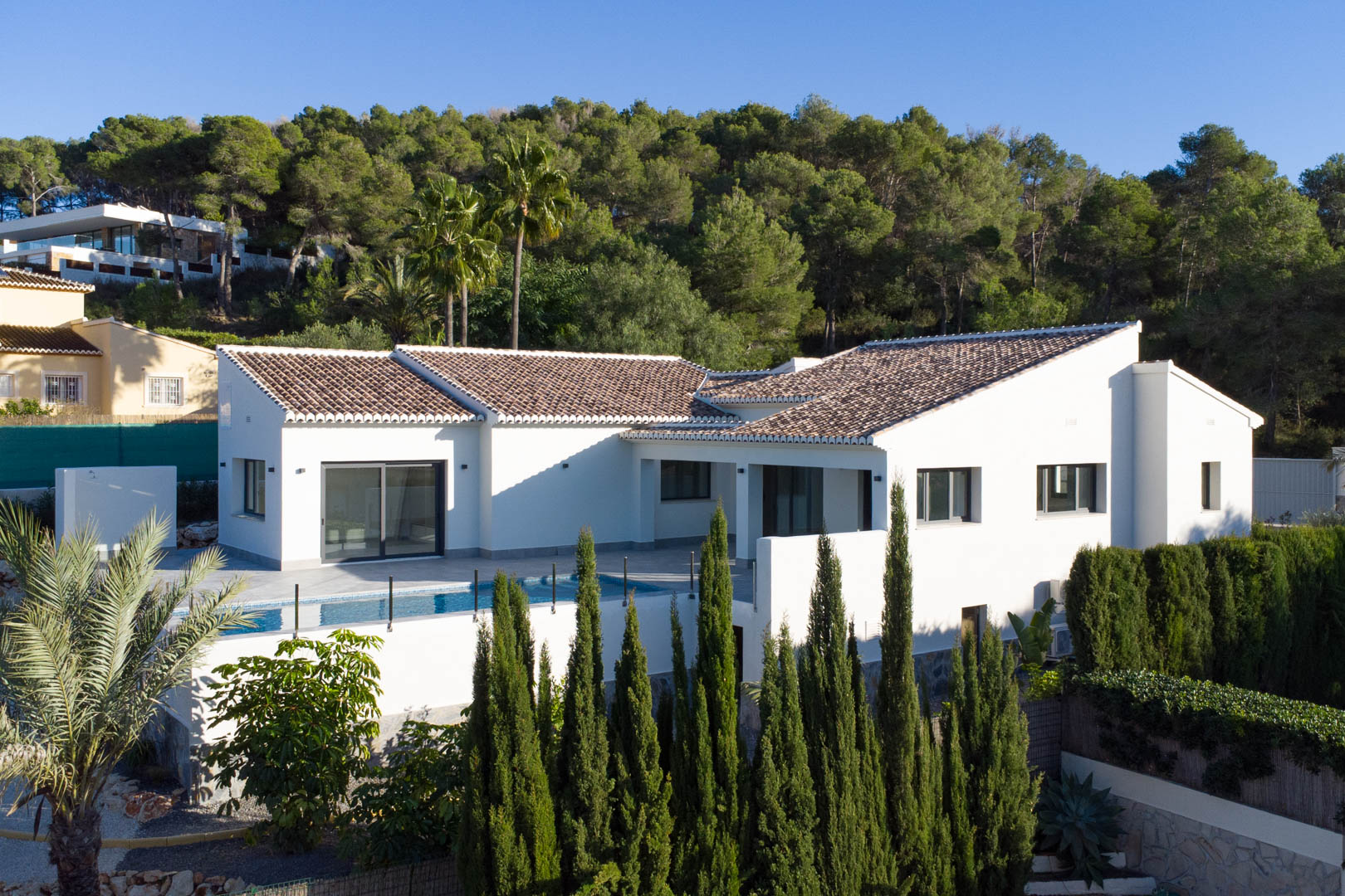 Buitenaanzicht van de villa in Piver, Jávea, met modern design, privézwembad en weelderige natuurlijke omgeving.