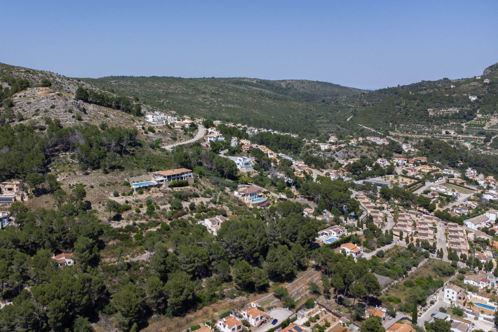 Luchtfoto van de verhoogde ligging in Alcalalí, met de woonpercelen op de heuvelrug die een weids uitzicht bieden over de Jalón-vallei en de natuurlijke omgeving.