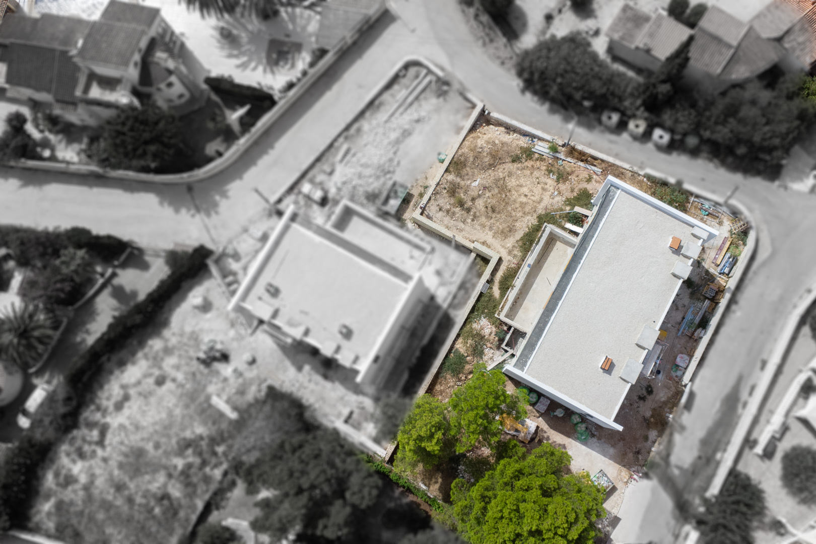 Luchtfoto van de voortgang van de bouw, waarop de structuur van de villa, het zwembad en de indeling van het vlakke perceel in Calpe te zien zijn.