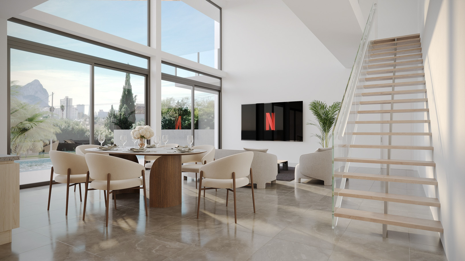 Woonkamer met dubbele hoogte, kamerhoge ramen met uitzicht op de Peñón de Ifach, gepolijste stenen vloeren en een zwevende houten trap met glazen balustrade.