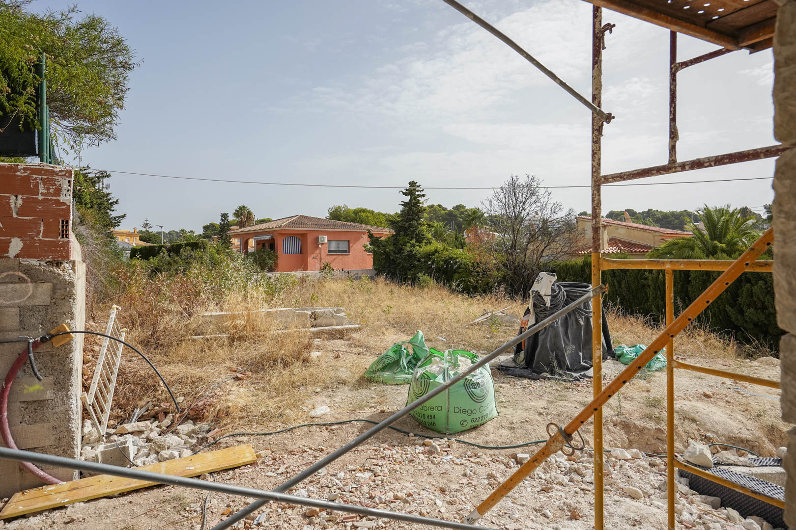 Zicht op het vlakke bouwperceel in Partida La Merced tijdens de eerste bouwfase, gelegen in een rustige woonomgeving nabij de kust van Calpe.