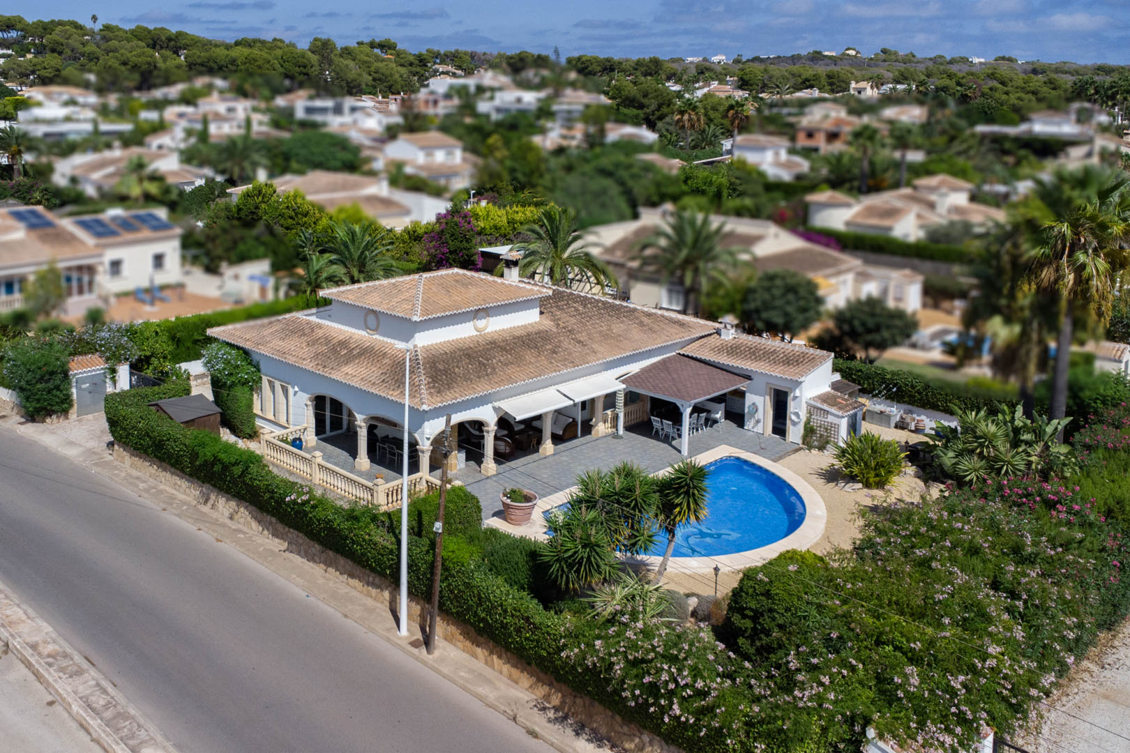 Luchtfoto van villa met privézwembad, overdekt terras en volgroeide tuin in Costa Nova, Jávea.