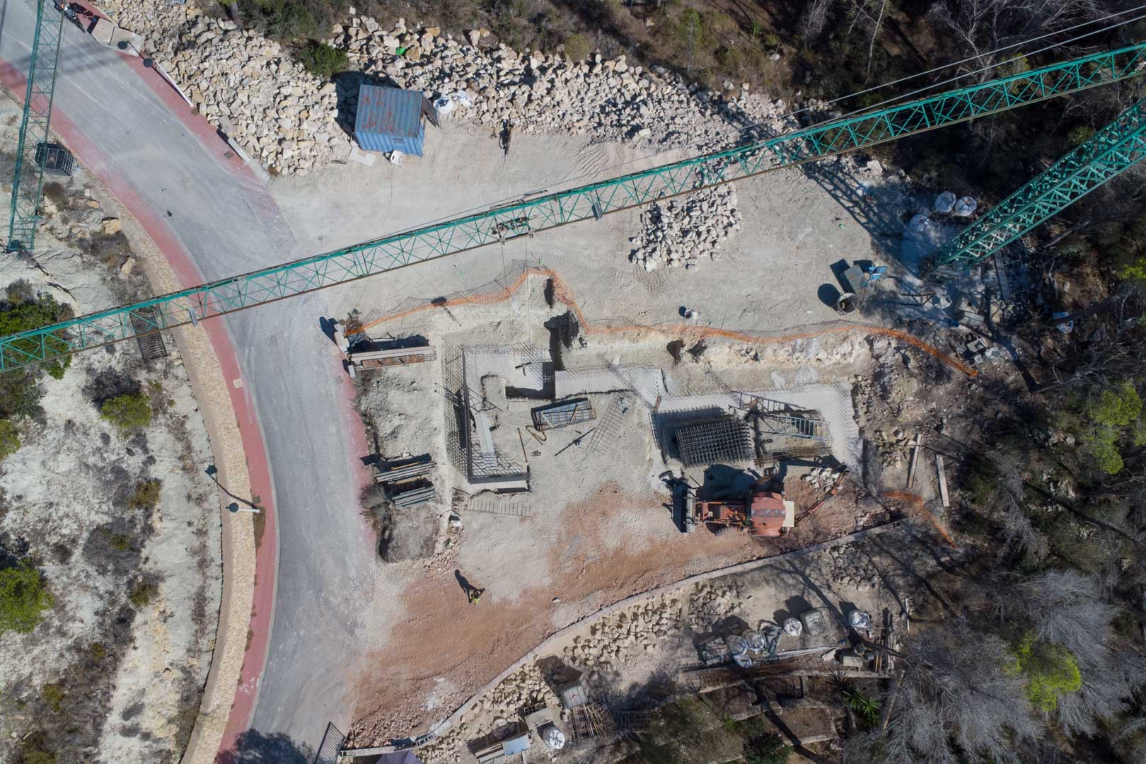 Luchtfoto van de eerste bouwfase, met de fundering, staalvlechtwerk en de bouwkraan op het perceel in Moraira.