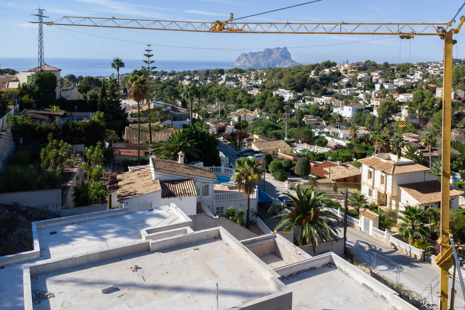Panoramisch uitzicht vanaf de bovenverdieping in aanbouw over de wijk San Jaime naar de Middellandse Zee en de iconische rots Peñón de Ifach.