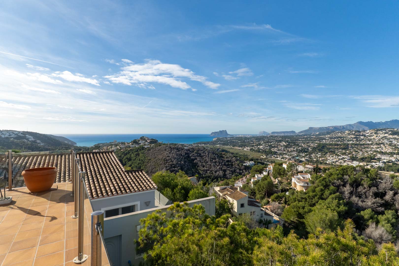 Betegeld terras met roestvrijstalen balustrade en panoramisch uitzicht op de Middellandse Zee, de Peñón de Ifach en de omliggende bergen van Moraira.