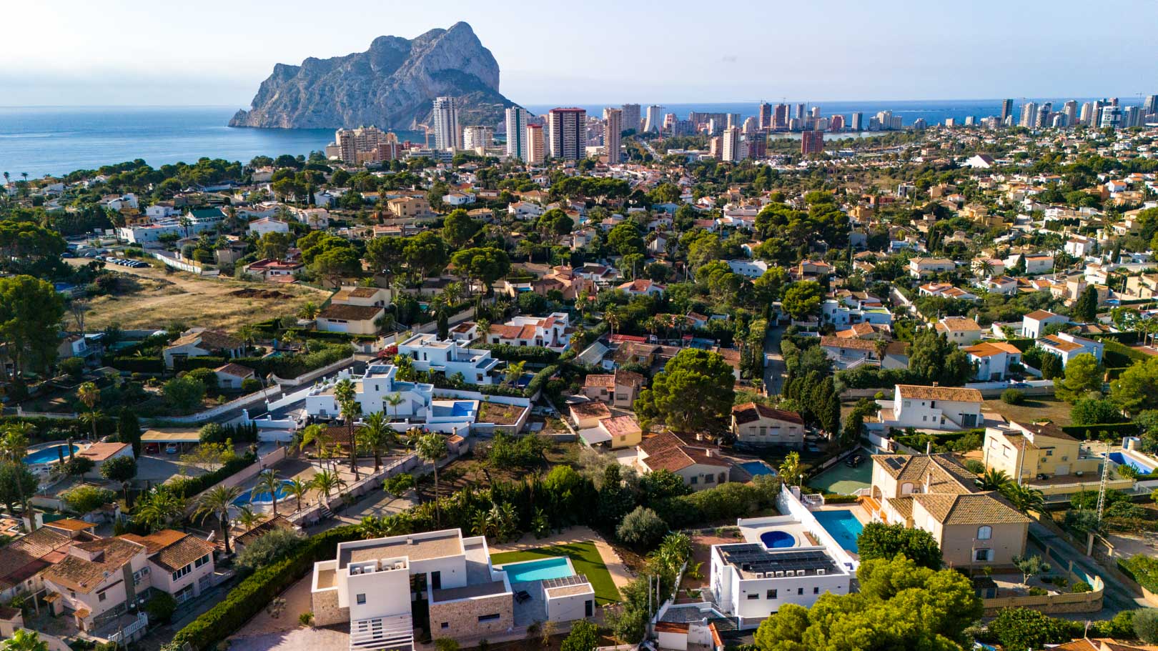 Panoramisch luchtfoto van de villa in Calpe, met de zonnepanelen op het dak en een weids uitzicht op de Peñón de Ifach en de Middellandse Zee.