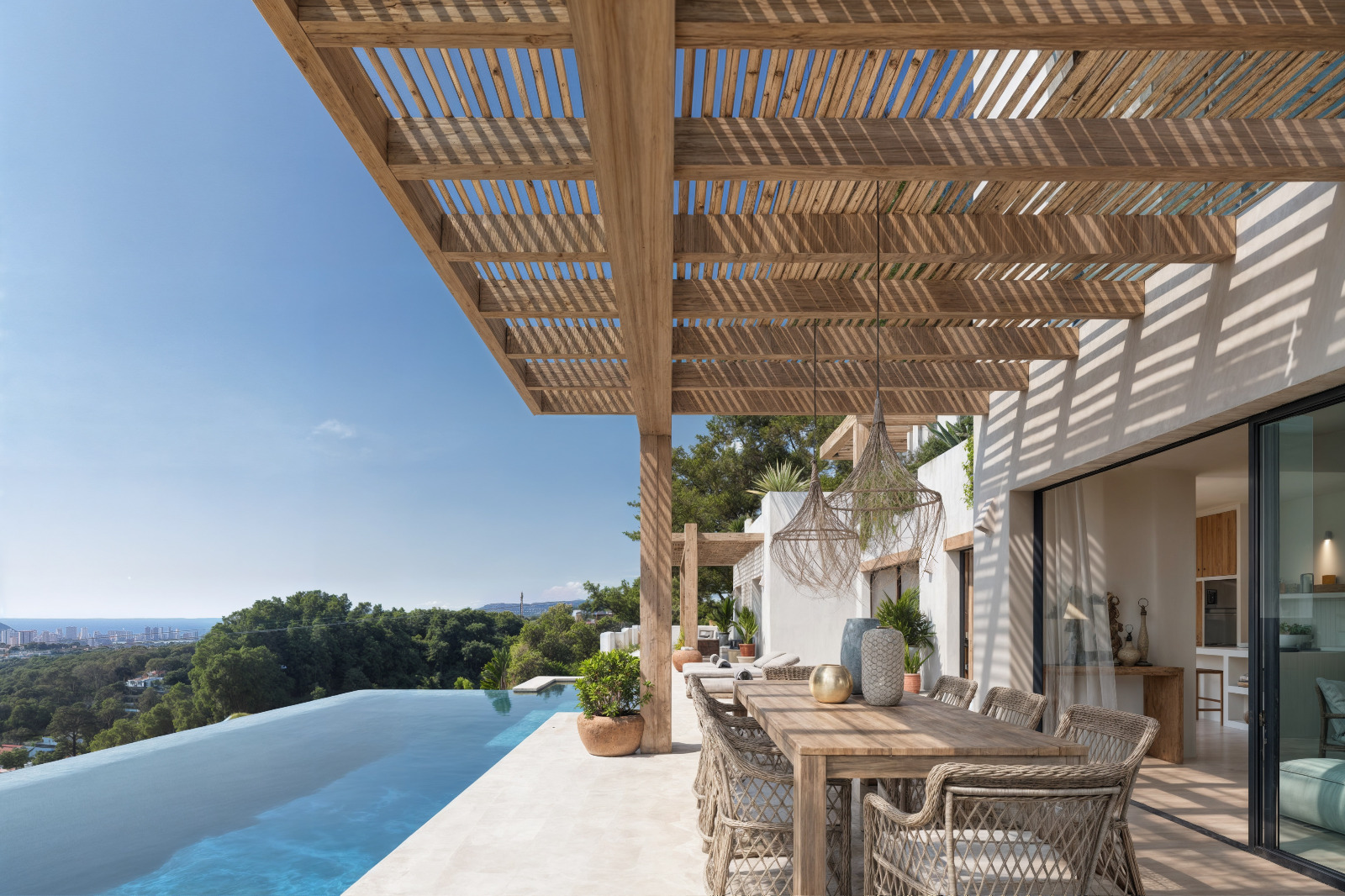Buitenterras met houten pergola, eethoek en overloopzwembad met panoramisch uitzicht op de Middellandse Zee en de kustlijn van Benissa.